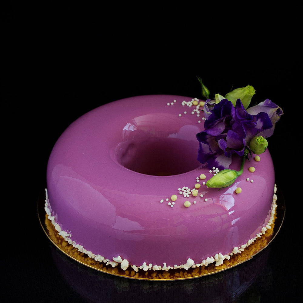 Purple cake with floral decoration on a black background
