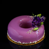 Purple cake with floral decoration on a black background