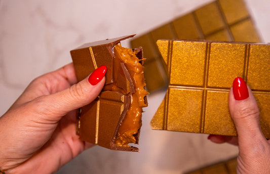 A Papouasie milk chocolate bar layered with caramel, salted peanut crunch, and dark chocolate ganache. A rich, multi-textured confectionery treat.