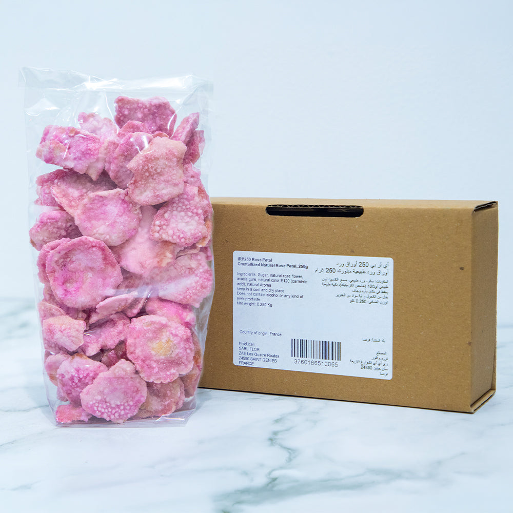 Pink candy in a clear bag with a cardboard box on a marble surface