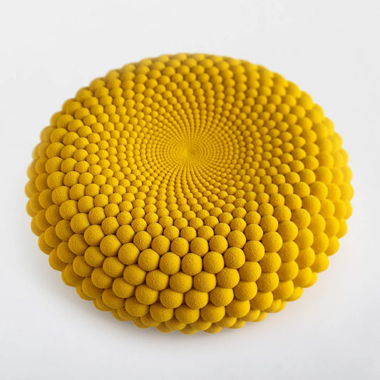Yellow velvet textured round cake on a white background