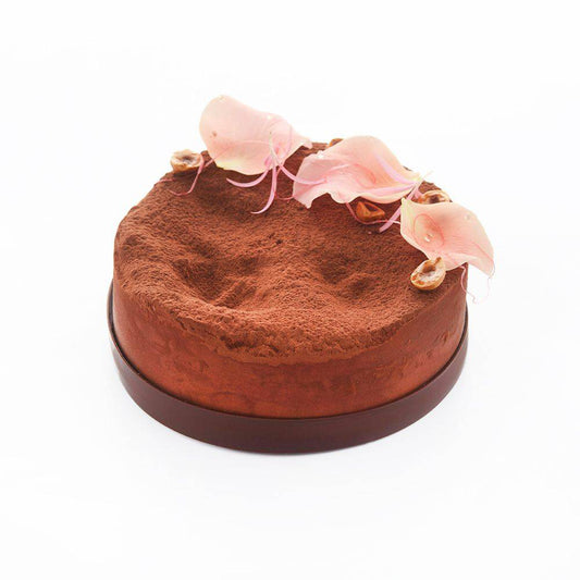 Round chocolate cake with pink flowers on a white background