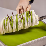 EVS09021_Pistachio_Gourmet_Variegato_for_Gelato_Pastry_6kg_Bella_Verde Ice cream dessert with green drizzle and chocolate sticks on a green surface