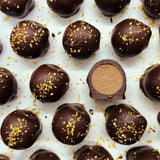 Chocolate truffles with gold sprinkles on a white background
