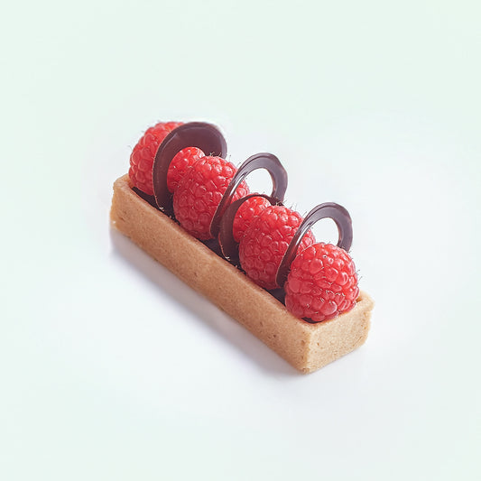 Small tart with raspberries and chocolate on a white background