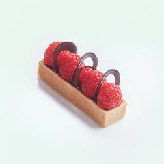 Small tart with raspberries and chocolate on a white background