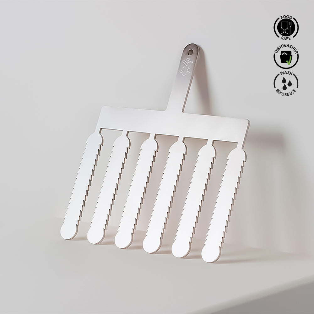 Metal spatula with serrated edges on a light gray background