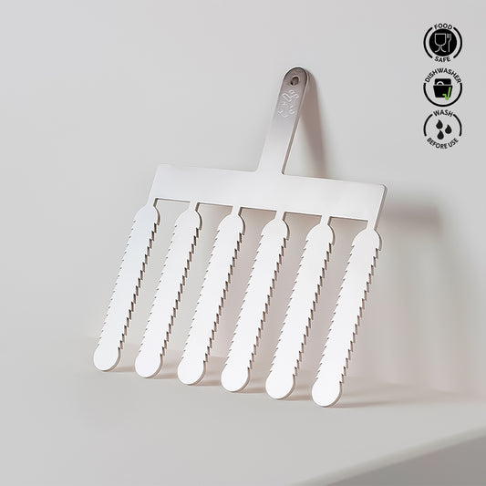 Metal spatula with serrated edges on a light gray background