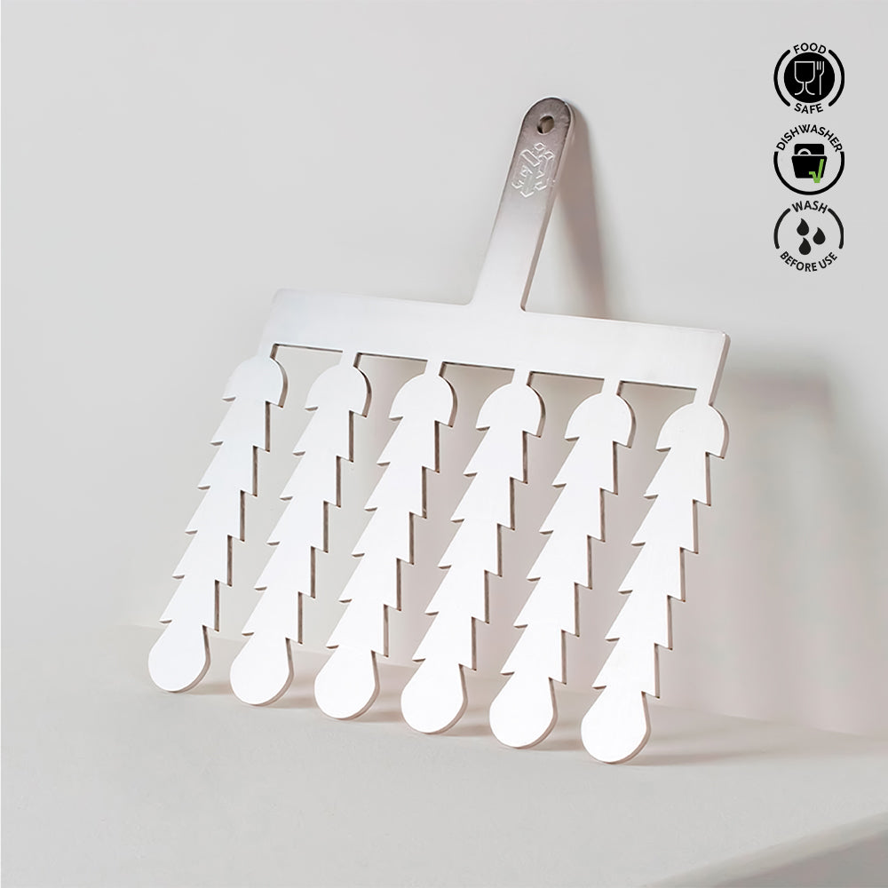 White spatula with multiple small spatulas attached, on a light gray background