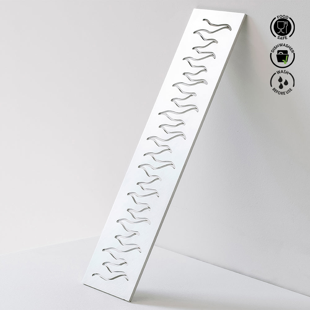 Metallic wavy patterned tray on a light gray background with food safe and dishwasher safe icons.