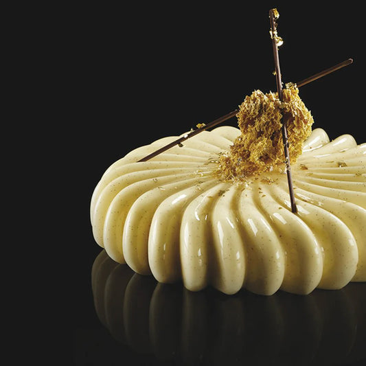 Decorative dessert with white cream and gold elements on a black background