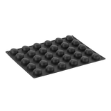 Black silicone mold with spherical cavities on a white background