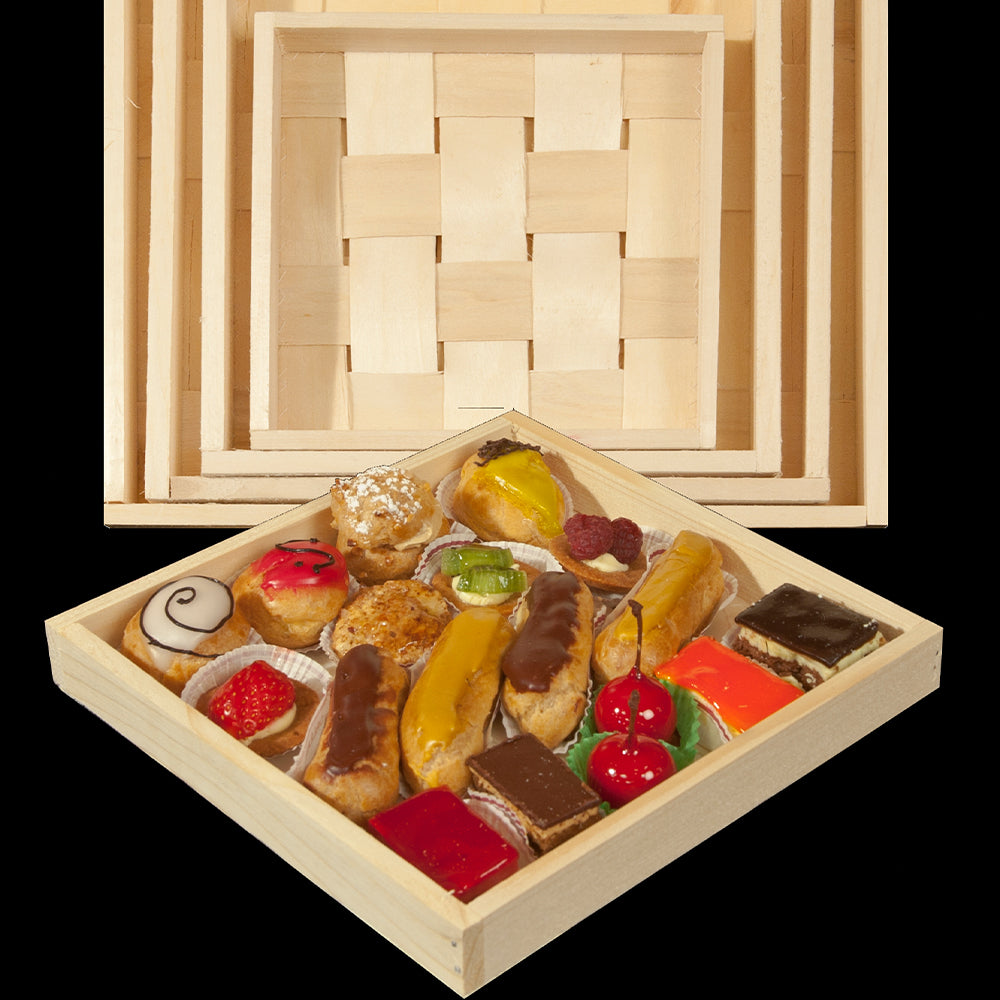 Wooden box of assorted pastries with a woven lid on a white background