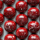 Close-up of red spherical bon bons with a speckled pattern on a white background